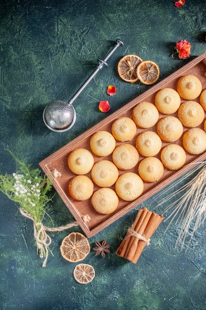 Вид сверху вкусное печенье внутри деревянной коробки на темно-синем фоне сахарное печенье бисквитный пирог цвет сладкий ореховый чайный торт