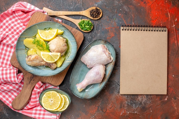 Вид сверху вкусная вареная курица с вареным картофелем и лимоном на темном фоне кухня блюдо масло цвет еда соус мясо фото ужин