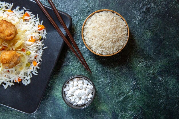 어두운 책상에 접시 안에 콩과 고기와 상위 뷰 맛있는 삶은 쌀