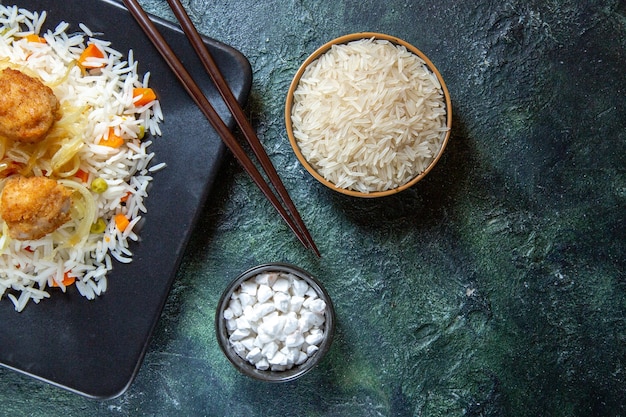 어두운 책상에 접시 안에 콩과 고기와 상위 뷰 맛있는 삶은 쌀