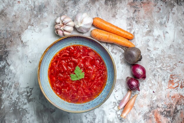 Вид сверху вкусного борща украинский свекольный суп со свежими овощами на темной поверхности