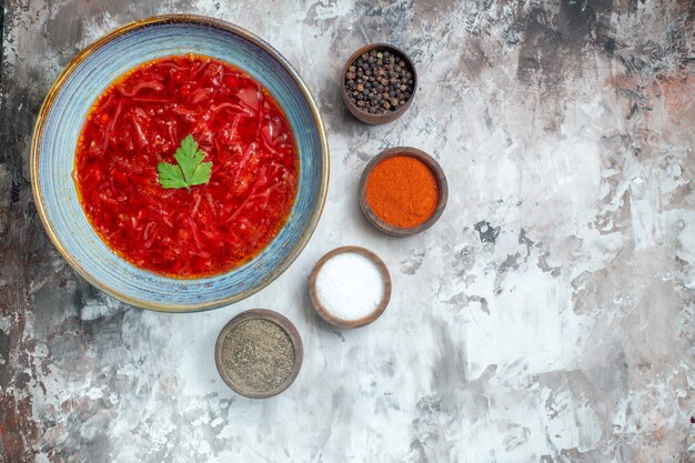 흰색 표면에 조미료와 함께 맛있는 보쉬 우크라이나 사탕 무우 수프의 상위 뷰