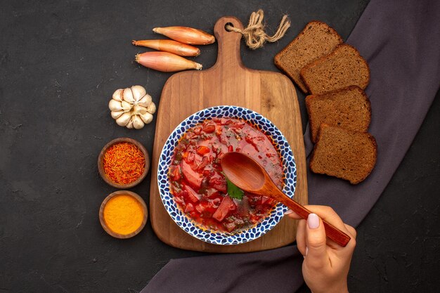 Top view tasty borsch ukranian beet soup with dark bread loafs on dark floor meal vegetable dinner food soup