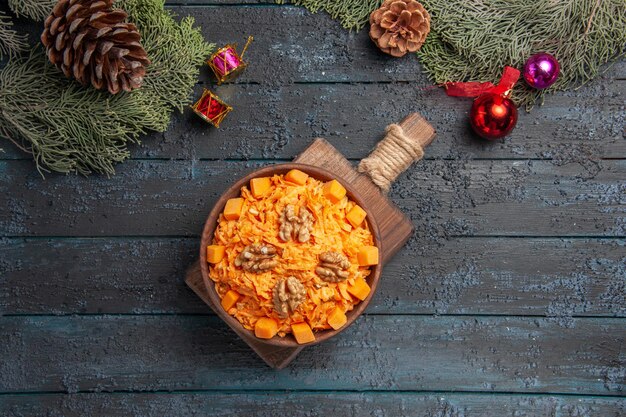 Top view tasty carrot salad with walnuts on dark-blue background health salad color diet food nut