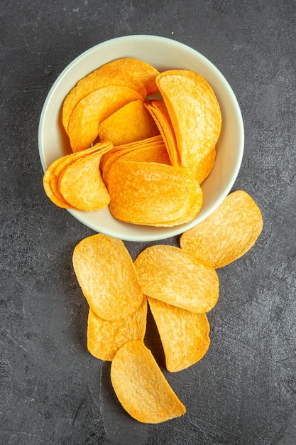 Top view tasty cheese chips inside plate on a dark background