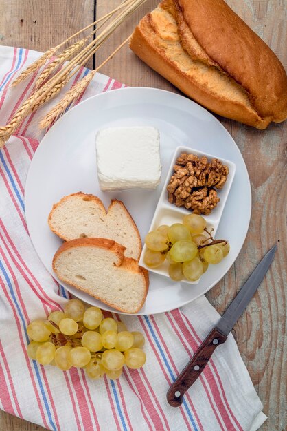 Вид сверху вкусный сыр с виноградом и грецкими орехами на тарелке