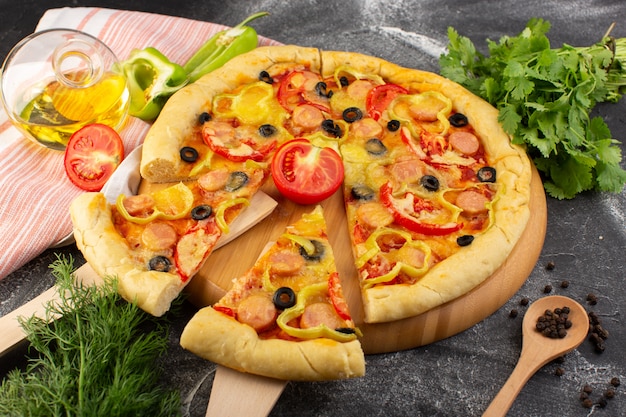 Вид сверху вкусная сырная пицца с красными помидорами, черными оливками, зеленью и сосисками на темном столе, фаст-фуд, выпечка из итальянского теста