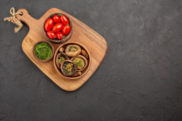 Top view tasty cooked mushrooms with tomatoes on dark background