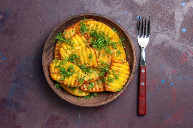 Top view tasty cooked potatoes with greens inside brown plate on dark surface cooking cips dinner food potato