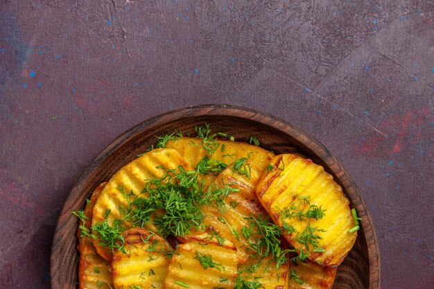 Top view tasty cooked potatoes with greens inside plate on dark desk cooking cips dinner food potato