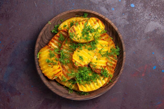 Top view tasty cooked potatoes with greens inside plate on dark surface cooking potato cips dinner food