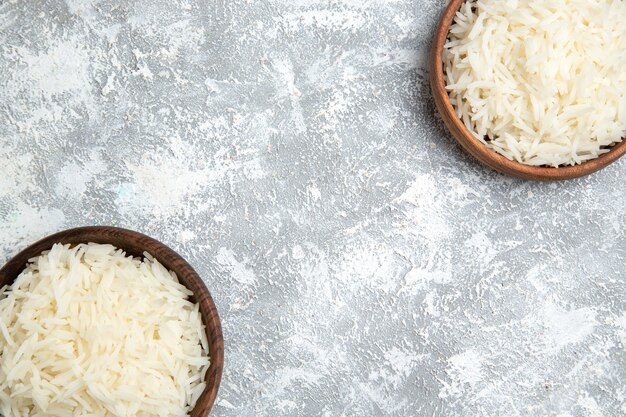 Top view tasty cooked rice inside brown plates on a white