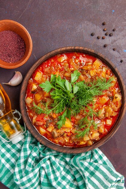 Top view tasty cooked vegetables sauce meal with greens on dark purple surface sauce meal dish food