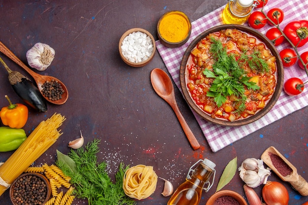 Вид сверху вкусной приготовленной овощной еды в соусе с овощами и приправами на темном столе, еда, ужин, блюдо, соус