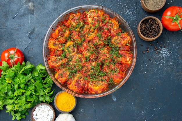 Top view tasty cooked vegetables with seasonings and greens on blue table dish meal meat cuisine food family taste