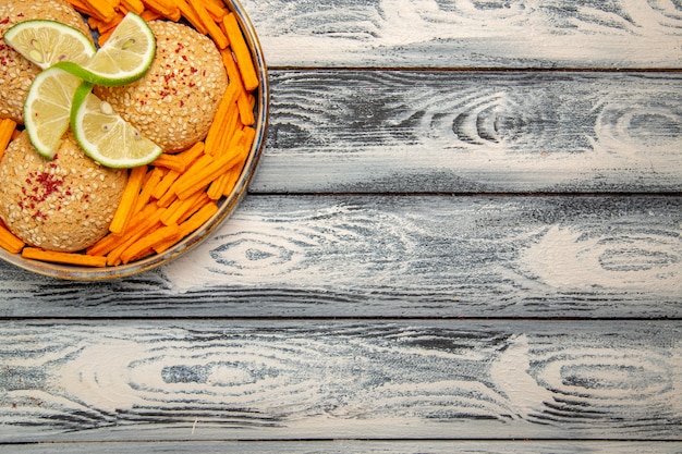 Top view tasty cookies with lemon slices and rusks on rustic grey desk biscuit sugar cake pie sweet cookies