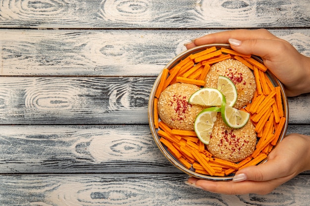 Вид сверху вкусное печенье с ломтиками лимона и сухариками на деревенском сером столе, печенье, сахарный торт, закуска, сладкое печенье