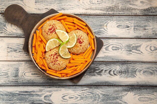 Top view tasty cookies with lemon slices and rusks on the rustic grey desk snack biscuit sugar sweet cake cookies