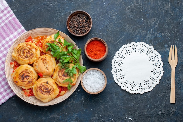 Top view tasty dough meal with meat inside plate along with seasonings on the dark background food meal meat vegetable