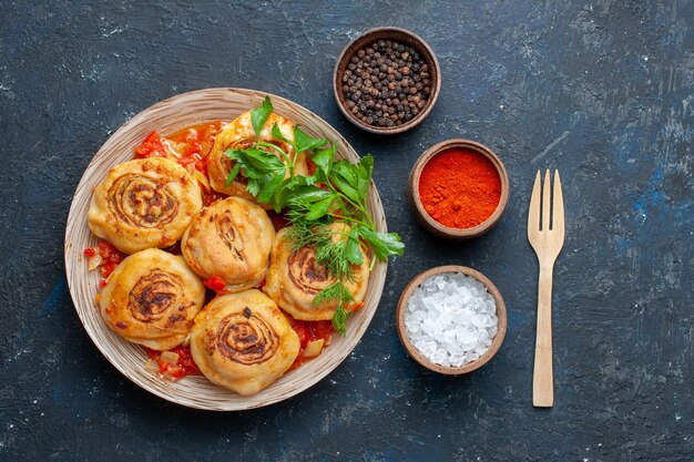 어두운 회색 책상 음식 식사 고기 야채에 조미료와 함께 접시 안에 고기와 함께 맛있는 반죽 식사를보기