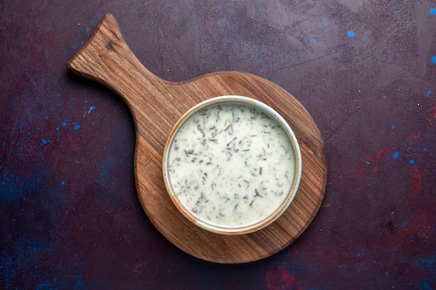 Top view tasty dovga from yogurt with greens inside on dark table, meal food soup green