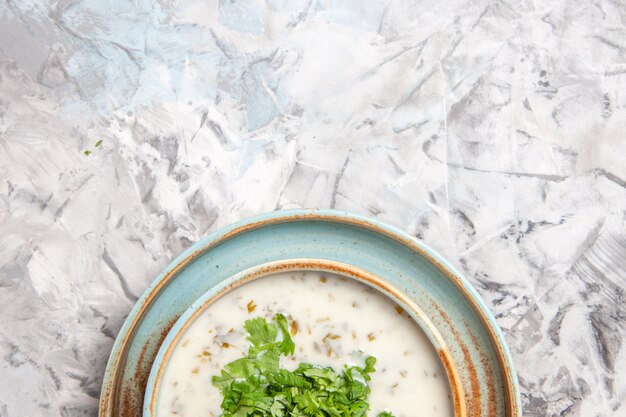 上面図白いテーブルミルクミール皿に緑のおいしいdovgaヨーグルトスープ