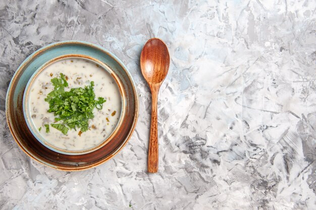 Top view tasty dovga yogurt soup with greens on white table milk soup dish dairy