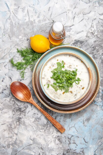 Top view tasty dovga yogurt soup with greens on white table milk soup dish dairy