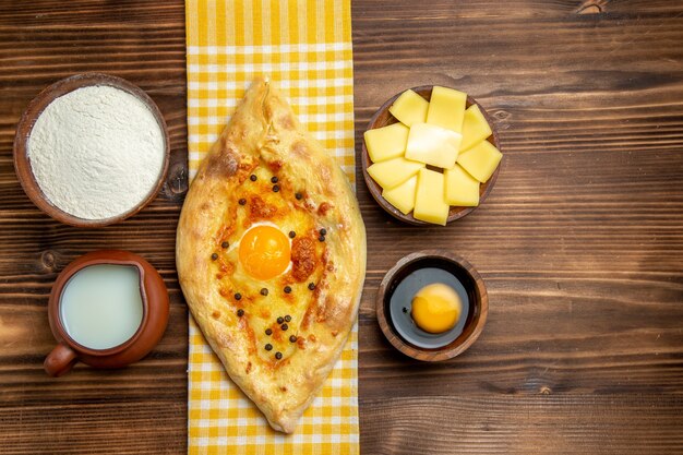 Top view tasty egg bread fresh off the oven with milk and cheese on a wooden desk meal bread bun egg