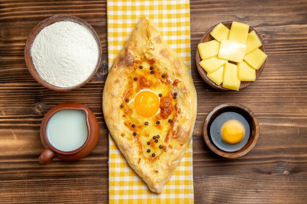 나무 책상 식사 빵 롤빵 계란에 우유와 치즈와 함께 오븐에서 신선한 상위 뷰 맛있는 계란 빵