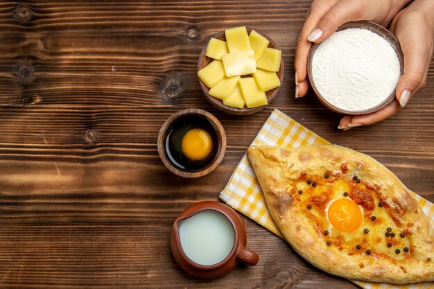 나무 책상 반죽에 우유와 함께 오븐에서 신선한 상위 뷰 맛있는 계란 빵 빵 빵 롤빵 계란