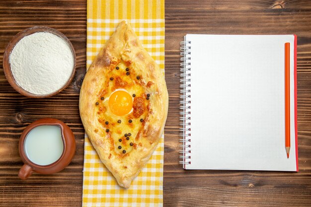 Top view tasty egg bread fresh off the oven with milk on the wooden desk dough bake bread bun eggs