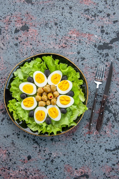 Foto gratuita vista dall'alto gustosa insalata di uova composta da insalata verde e olive su sfondo chiaro