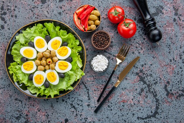 top view tasty egg salad with seasonings and olives on light background