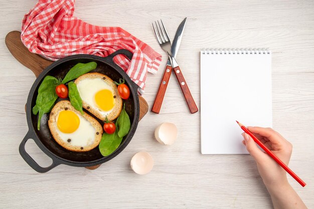 Top view tasty egg toasts inside pan with fresh eggs on white background bread color lunch dish breakfast meal tea