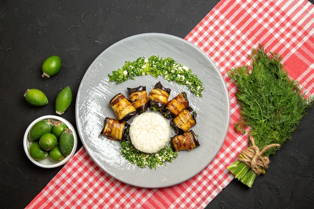 Top view tasty eggplant rolls cooked meal with rice on black