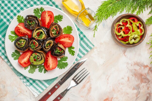 Top view tasty eggplant rolls with seasonings tomatoes and greens