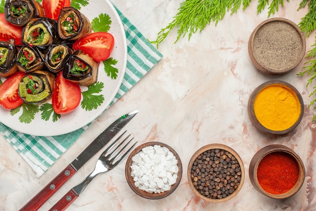 Free photo top view tasty eggplant rolls with seasonings tomatoes and greens