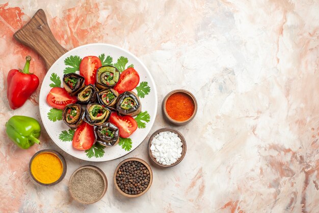 Top view tasty eggplant rolls with tomatoes and different seasonings