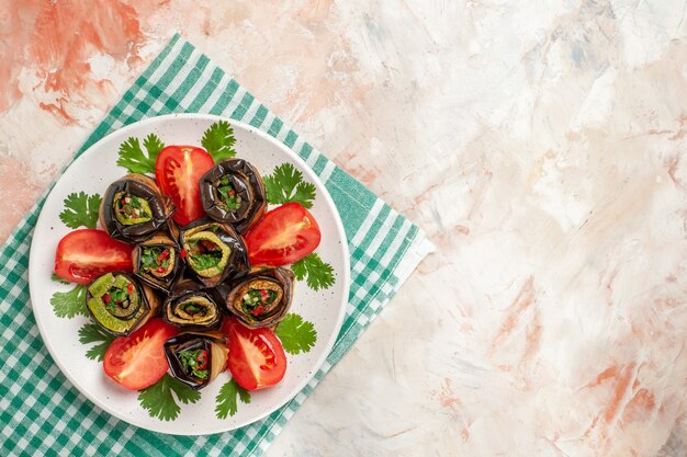 Top view tasty eggplant rolls with tomatoes and greens