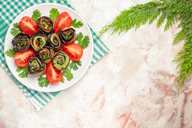 Вид сверху вкусные рулетики из баклажанов с помидорами и зеленью