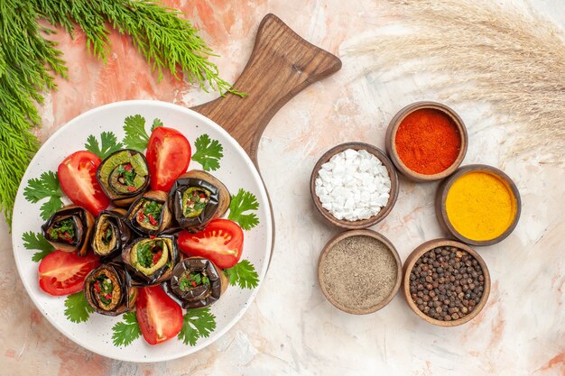 Top view tasty eggplant rolls with tomatoes and seasonings