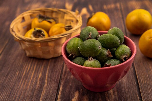 나무 표면에 양동이에 감 과일 그릇에 맛있는 신선한 feijoas의 상위 뷰