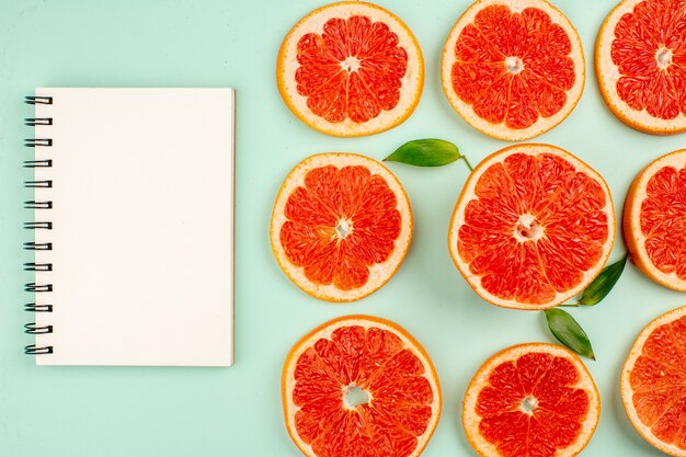 Top view of tasty fresh grapefruits lined on light-blue surface