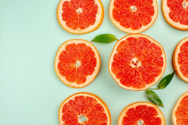 Top view of tasty fresh grapefruits lined on light-blue surface