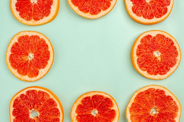 Top view of tasty fresh grapefruits lined on light-blue surface
