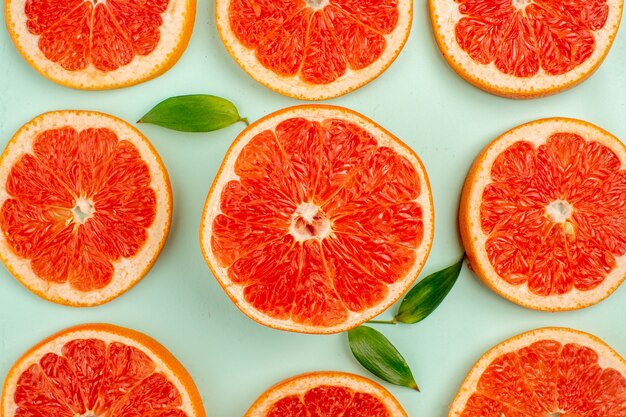 Top view of tasty fresh grapefruits lined on light-blue surface