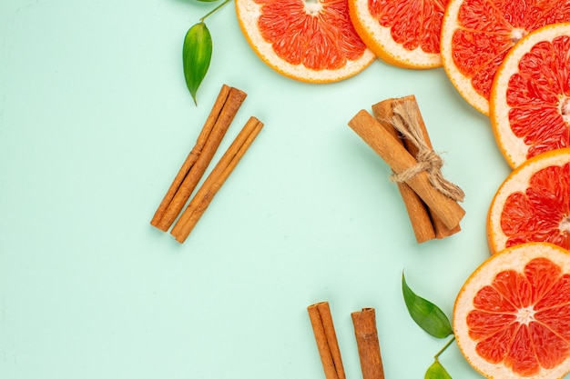 Top view of tasty fresh grapefruits with cinnamon on light-blue surface