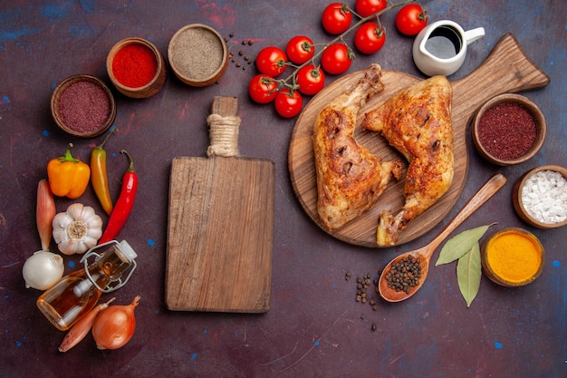 Top view tasty fried chicken with fresh vegetables and seasonings on dark background food chicken meal vegetable meat