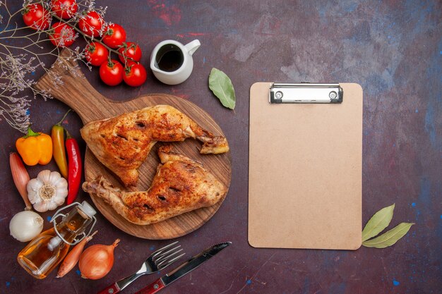 Top view tasty fried chicken with fresh vegetables and seasonings on dark background food chicken meal vegetables meat